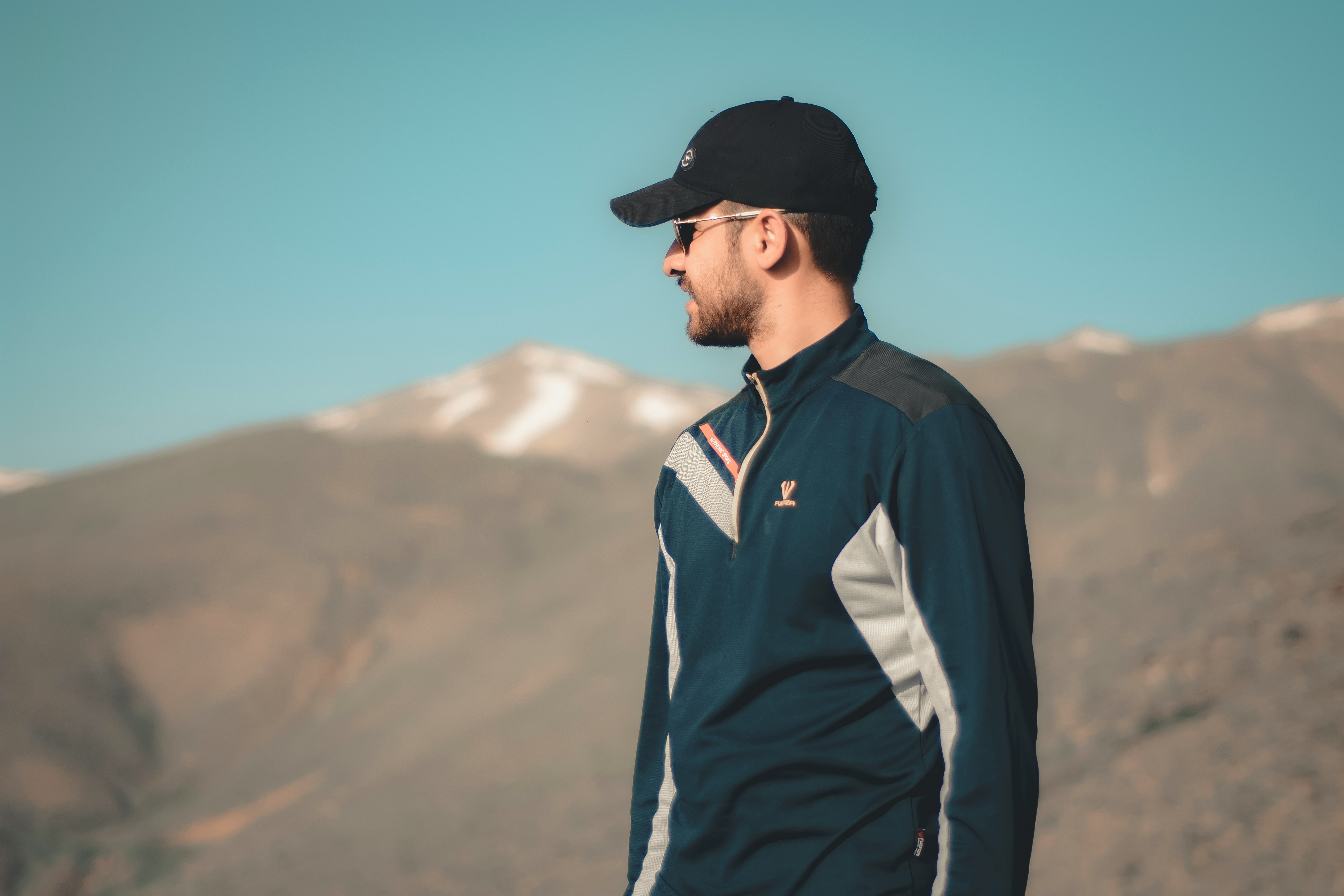 man in black and white adidas jacket and black cap